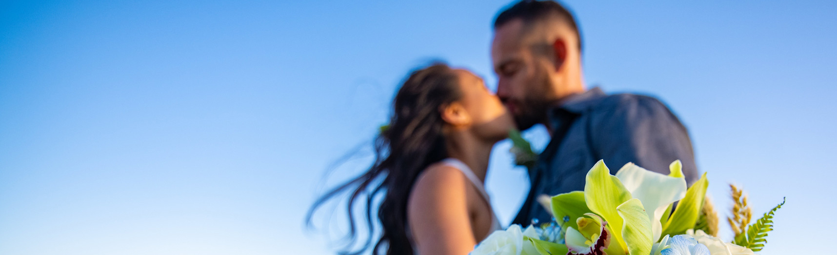 Stay A couple sharing a wedding kiss on the beach
