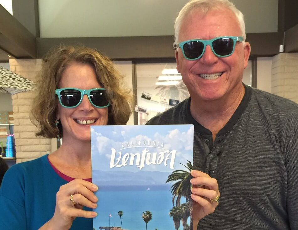 Two volunteers holding a visitor guide