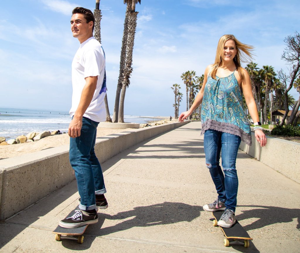 Man and woman skateboarding on promenade