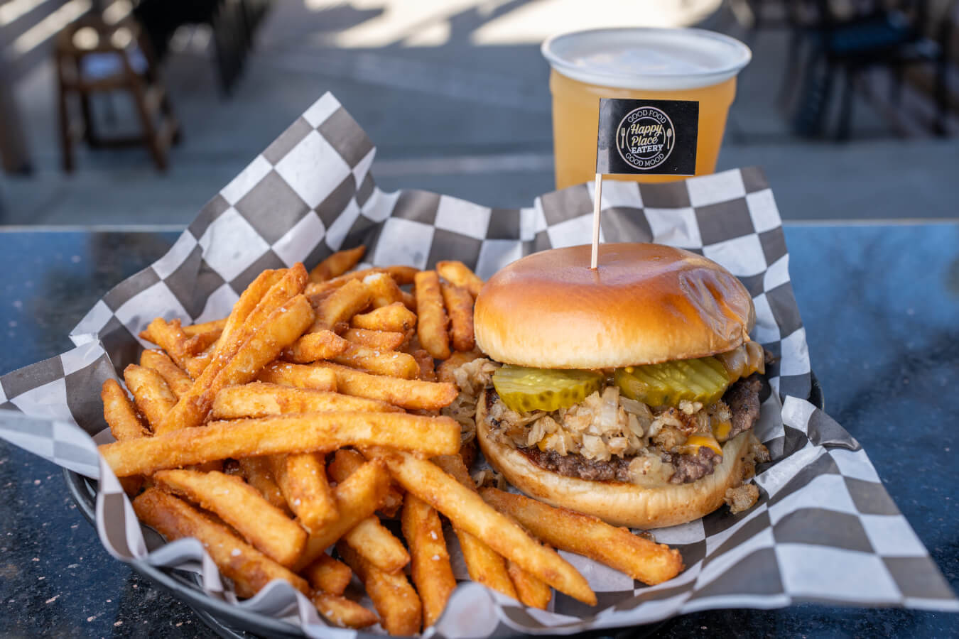 Ventura's Best Sports Bars for Game Day plate full of fries and a burger with a beer at Happy Place Eatery, one of Ventura's sports bars