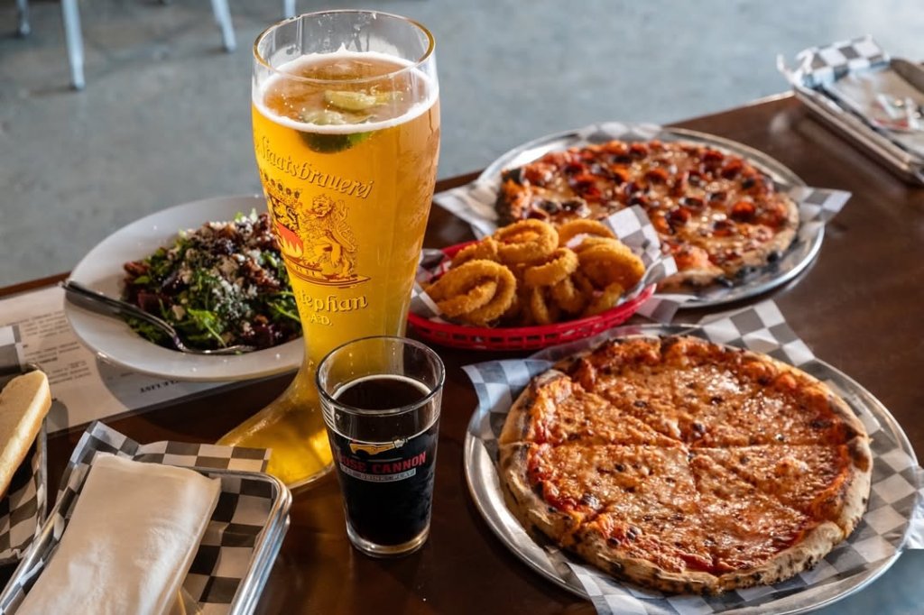 Ventura's Best Sports Bars for Game Day Plates full of pizza and onion rings with a boot glass of beer at one of Venturas sports bars, Loose Cannon