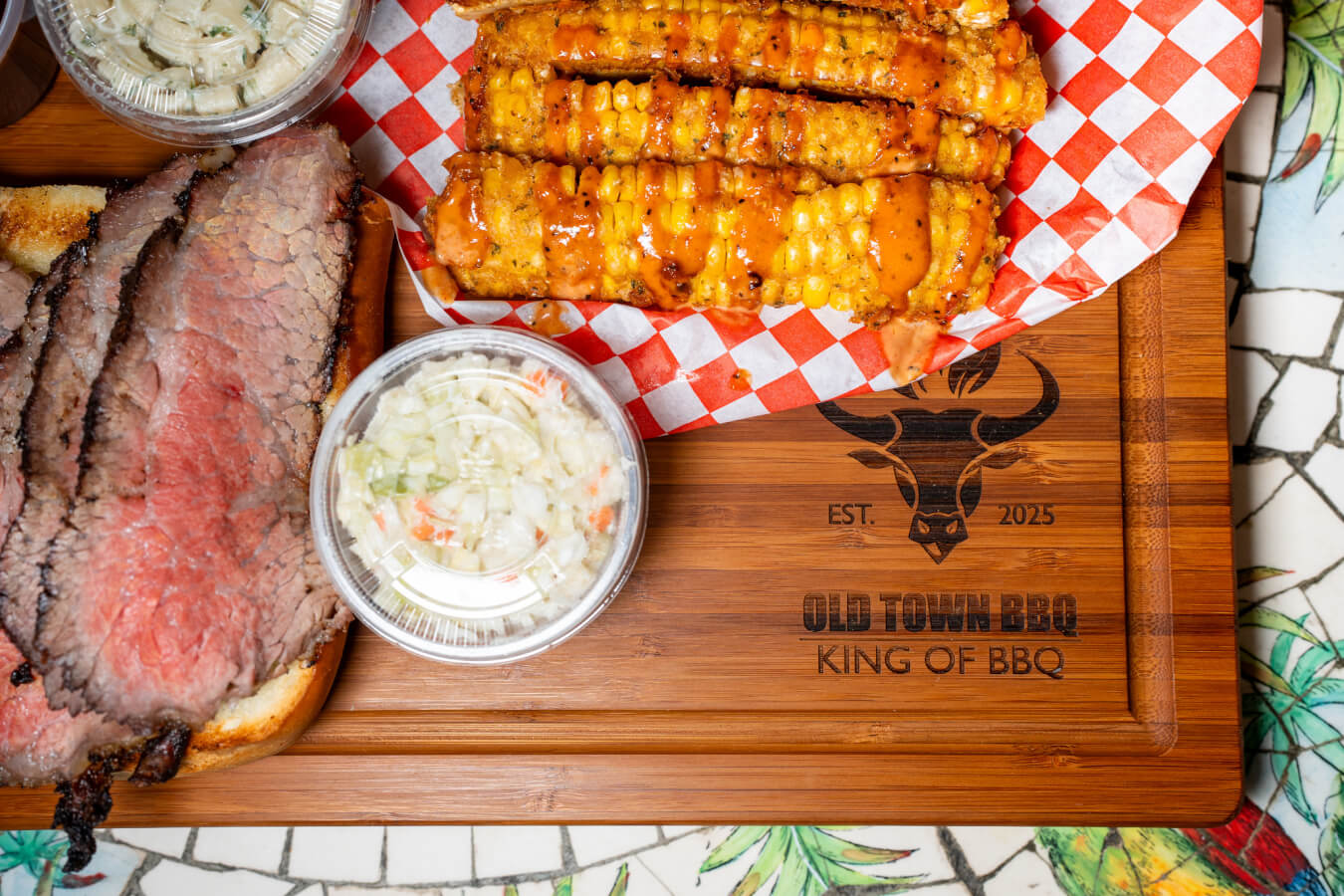 A top down view of a plate of tri-tip, corn, and coleslaw at Old Town BBQ in Ventura, California